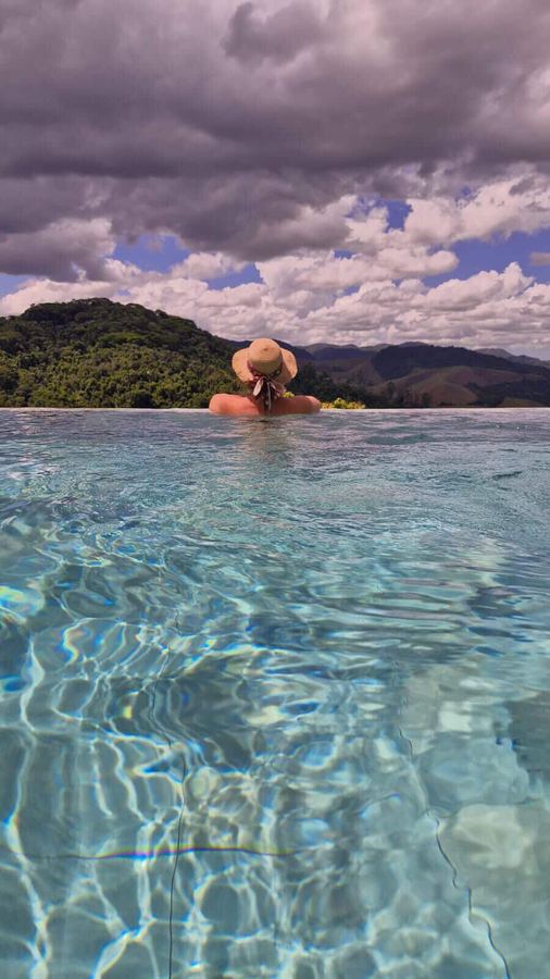 Hóspede na piscina olhando as montanhas